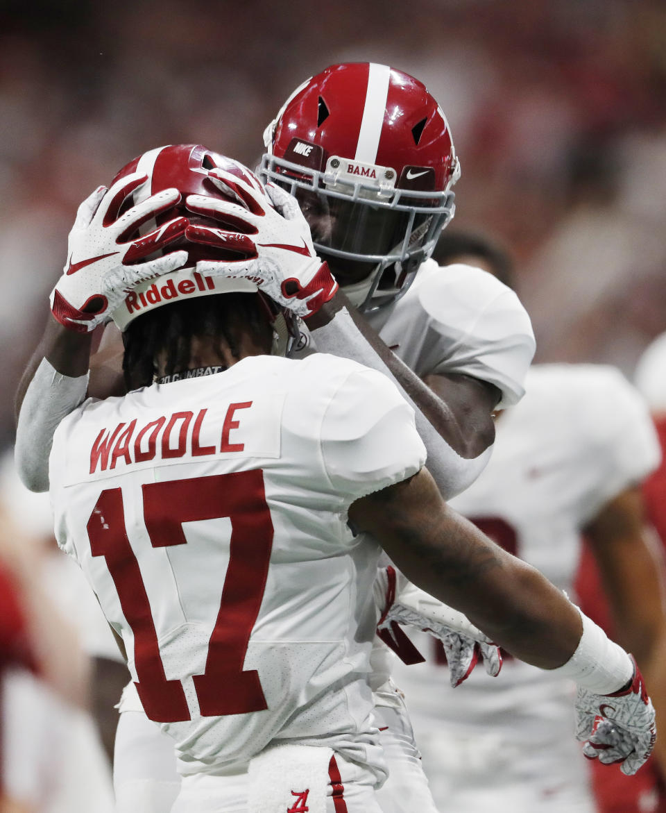 Alabama wide receiver Tyrell Shavers (14) embraces Alabama wide receiver Jaylen Waddle (17) after a touchdown against Georgia during the second half of the Southeastern Conference championship NCAA college football game, Saturday, Dec. 1, 2018, in Atlanta. (AP Photo/John Bazemore)