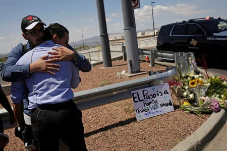 People react at the site of a mass shooting the day after at a Walmart in El Paso
