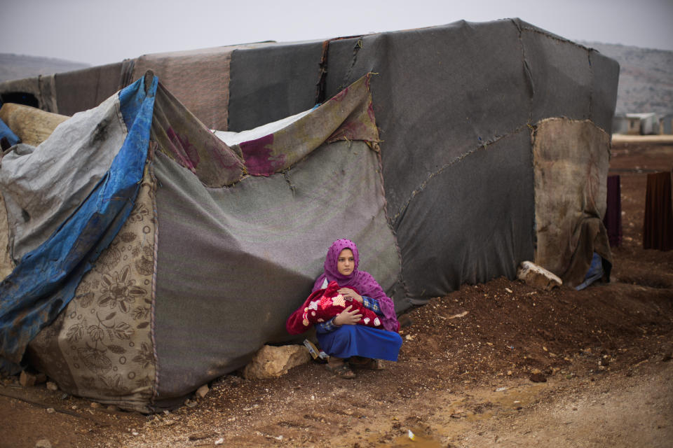 A Syrian young woman holds a baby in a refugee camp for displaced people supported by the Turkish Red Crescent in Sarmada district, north of Idlib city, Syria, Thursday, Nov. 25, 2021. (AP Photo/Francisco Seco)