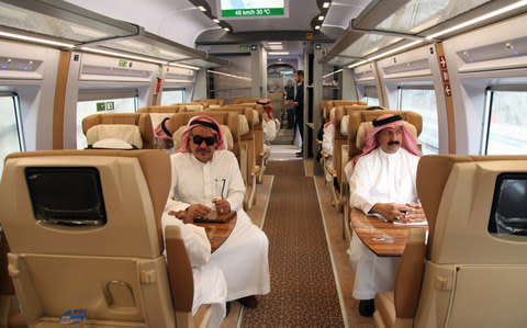Saudi officials sitting in a high-speed train, ahead of their trip, at a station in Saudi Arabia's holy city of Mecca.  - Credit: BANDAR ALDANDANI/AFP/Getty Images