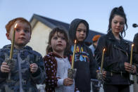 Children hold a candle light vigil outside the home in Timaru, New Zealand, Thursday, Sept. 23, 2021 for sisters Maya, Karla and Liane Dickason, originally from South Africa, who were killed in their home on Sept. 16. People in the town of Timaru held an evening vigil outside the home of three young girls who were killed last week in a crime that shocked New Zealand. The girls' mother Lauren Dickason has been charged with murder. (George Heard/New Zealand Herald via AP)