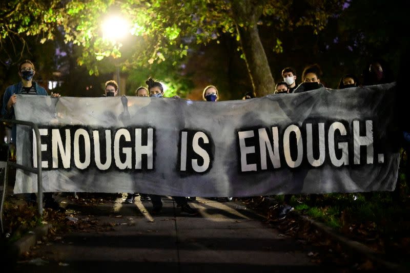 Protestors hold a banner reading "enough is enough" during a rally after the death of Walter Wallace Jr., a Black man who was shot by police in Philadelphia