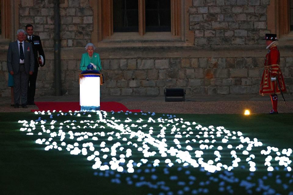 Britain's Queen Elizabeth II touches the Commonwealth Nations Globe to start the lighting of the Principal Beacon outside of Buckingham Palace in London, from the Quadrangle at Windsor Castle in Windsor, west of London, on June 2, 2022, as part of Platinum Jubilee celebrations. - The queen will be seen again at Windsor Castle, west of London, as more than 2,800 beacons are lit at Buckingham Palace and across the UK, including atop the four highest peaks, as well as on the Channel Islands, the Isle of Man, and British Overseas Territories. Flaming tributes will be seen in 54 Commonwealth capitals across five continents, from Tonga and Samoa in the South Pacific to Belize in the Caribbean. (Photo by Adrian DENNIS / POOL / AFP) (Photo by ADRIAN DENNIS/POOL/AFP via Getty Images)