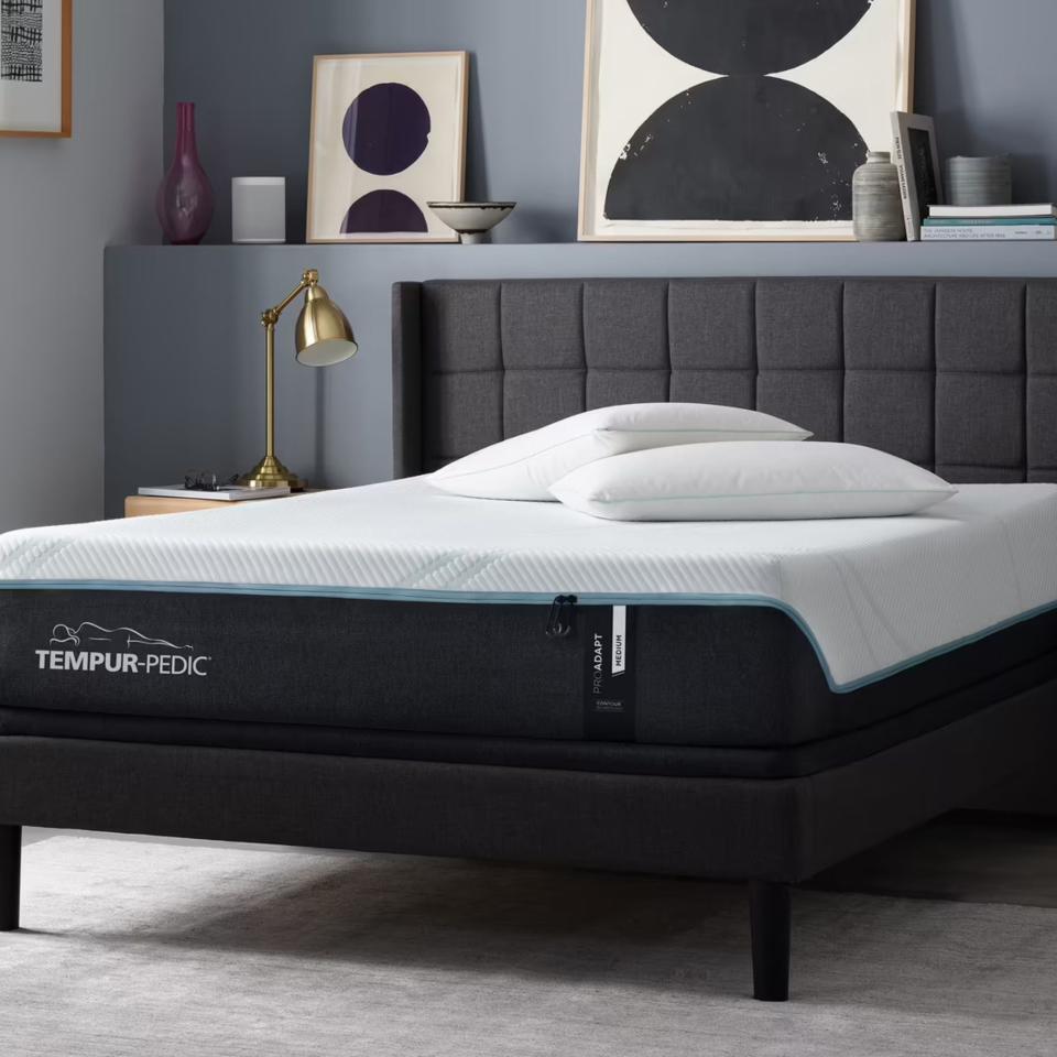 A Tempur-Adapt mattress on a bed against a gray wall.