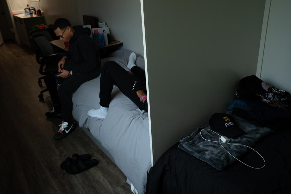 Fisk University freshmen Brandon Nashe, left, and Nick Okubazgi check their phones as they wait for a ride Wednesday evening, Aug. 9, 2023. The two share one of the new container homes at the school.Wednesday evening, Aug. 9, 2023.