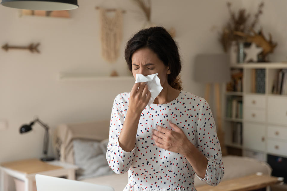 Stay at home. Unhealthy ill young female sneeze wipe blow nose with paper tissue suffer of flu rhinitis cold respiratory infection. Sick woman feeling bad having hay fever seasonal allergy aggravation