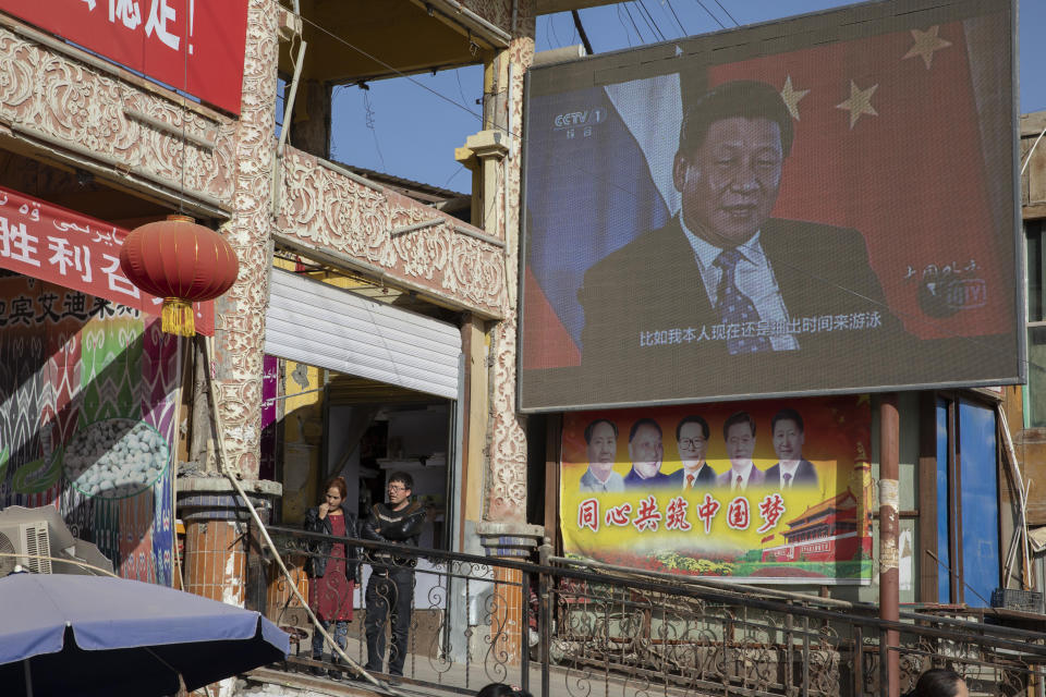 Chinese President Xi Jinping is seen on a screen near a bazaar in Hotan in western China's Xinjiang region, China, Friday, Nov. 3, 2017. The accusation of genocide by U.S. Secretary of State Mike Pompeo against China touches on a hot-button human rights issue between China and the West. (AP Photo/Ng Han Guan)