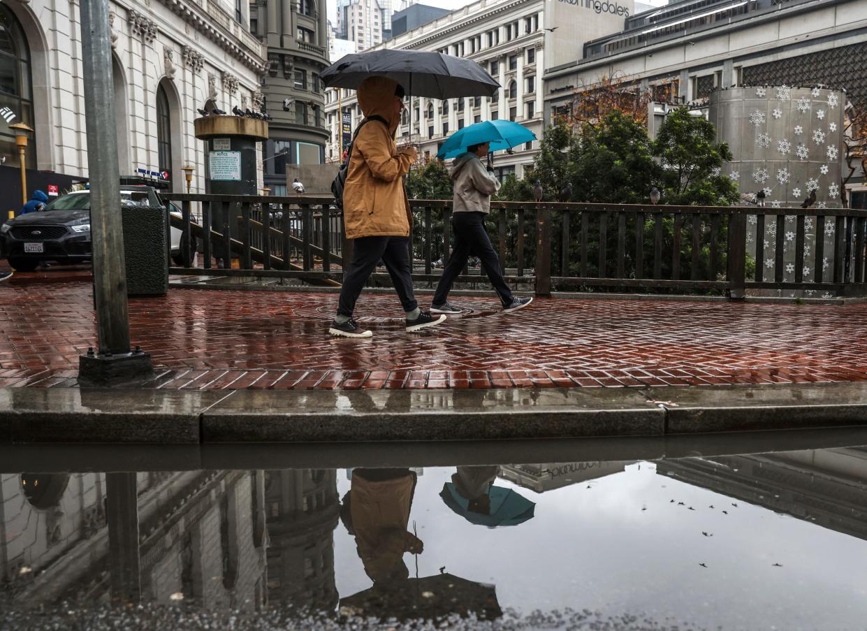 People navigate through the rain in downtown San Francisco on Monday, Dec. 18, 2023. (Gabrielle Lurie/San Francisco Chronicle via AP) ORG XMIT: 3CAFRA602