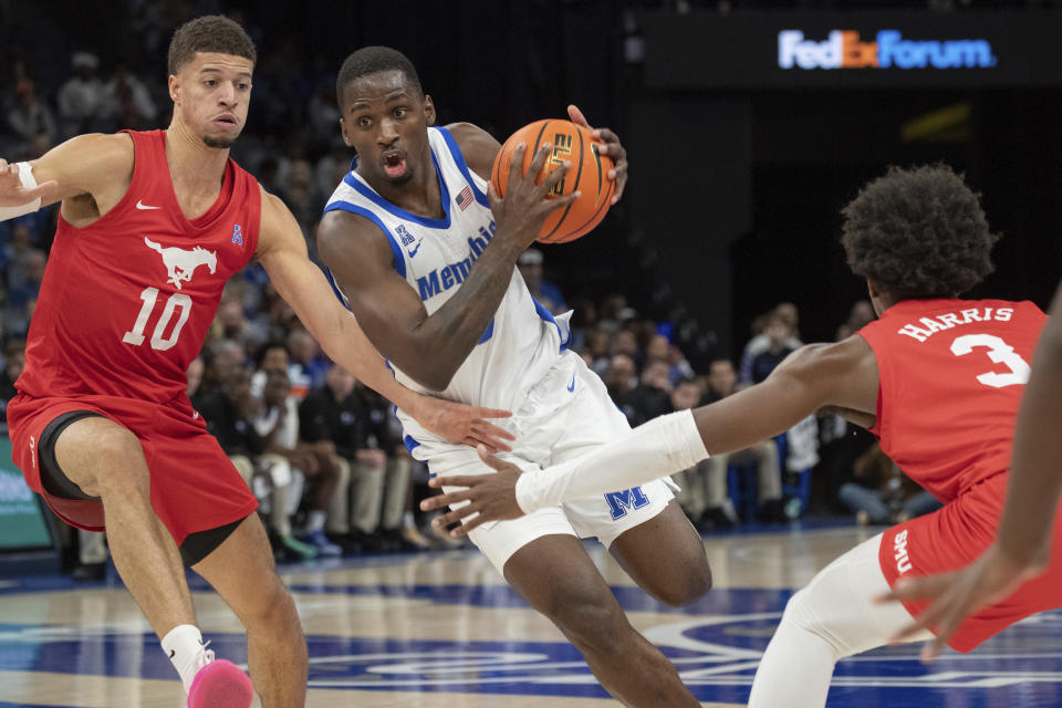 Memphis forward David Jones (8) drives between the defense of SMU forward Samuell Williamson (10) and guard Chuck Harris (3) during the first half of an NCAA college basketball game Sunday, Jan. 7, 2024, in Memphis, Tenn. (AP Photo/Nikki Boertman)