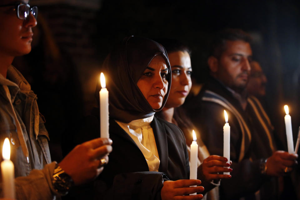 Activists, protesting the killing of Saudi journalist Jamal Khashoggi, hold a candlelight vigil outside Saudi Arabia's consulate in Istanbul, Thursday, Oct. 25, 2018. A group of Arab and international public, political and media figures are establishing a global association called "Khashoggi's Friends Around the World"; "to achieve justice for the freedom martyr".(AP Photo/Lefteris Pitarakis)