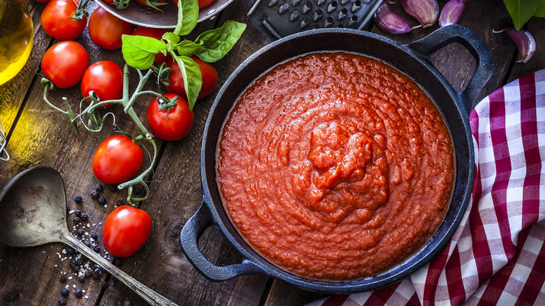 pot filled with marinara sauce next to ingredients