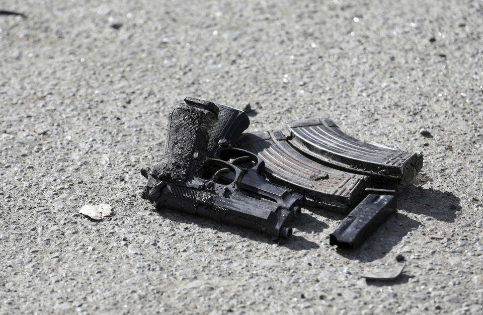 Pistols of security personnel are seen on the ground after a deadly bomb attack in Kabul, Afghanistan, Wednesday, Feb. 10, 2021. (AP Photo/Rahmat Gul)