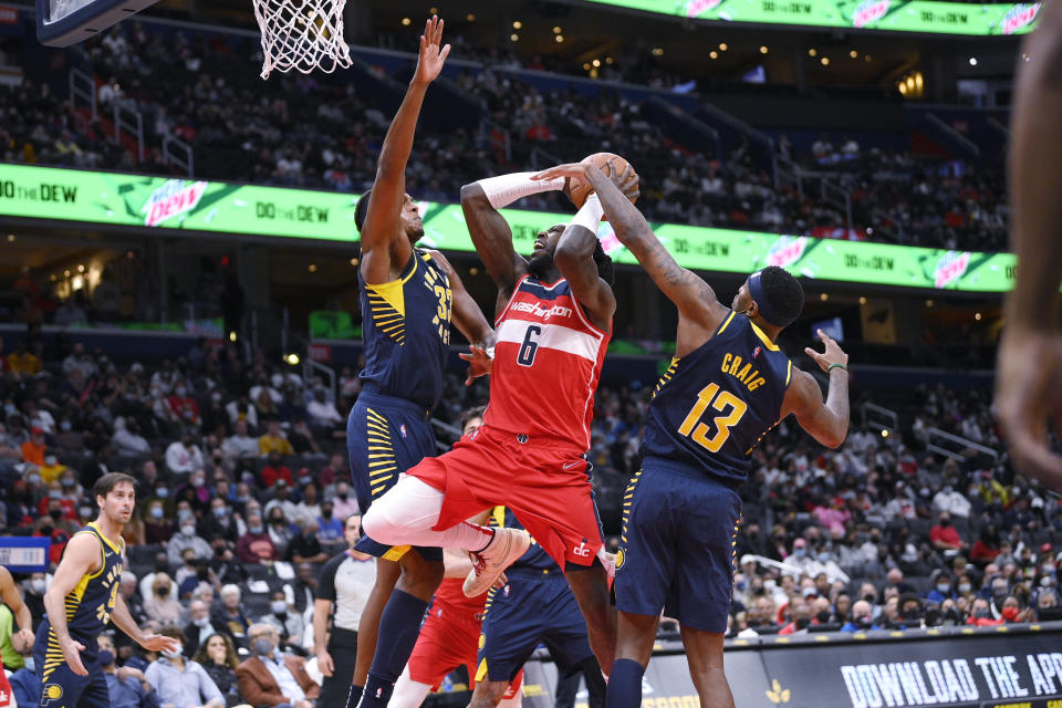 Washington Wizards center Montrezl Harrell (6) goes to the basket against Indiana Pacers forward Torrey Craig (13) and center Myles Turner (33) during the first half of an NBA basketball game Friday, Oct. 22, 2021, in Washington. (AP Photo/Nick Wass)