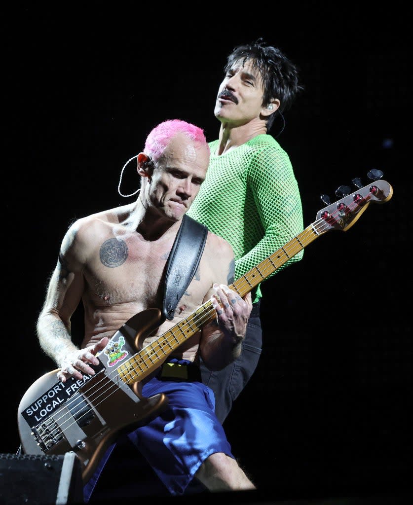 Two members of Red Hot Chili Peppers, Flea playing bass and Anthony Kiedis singing, perform live on stage