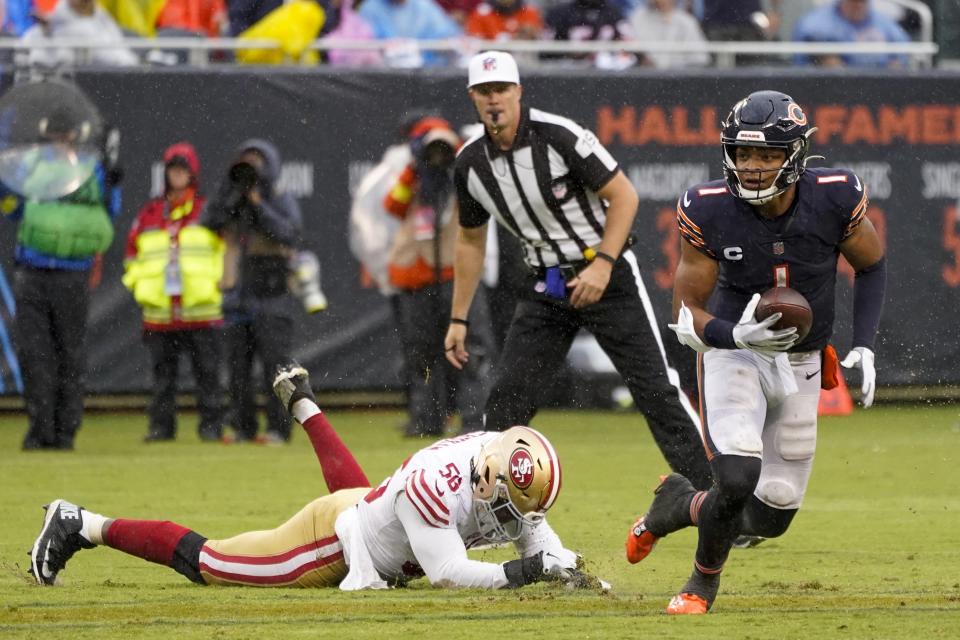 Chicago Bears' Justin Fields runs past San Francisco 49ers' Samson Ebukam during the first half of an NFL football game Sunday, Sept. 11, 2022, in Chicago. (AP Photo/Charles Rex Arbogast)