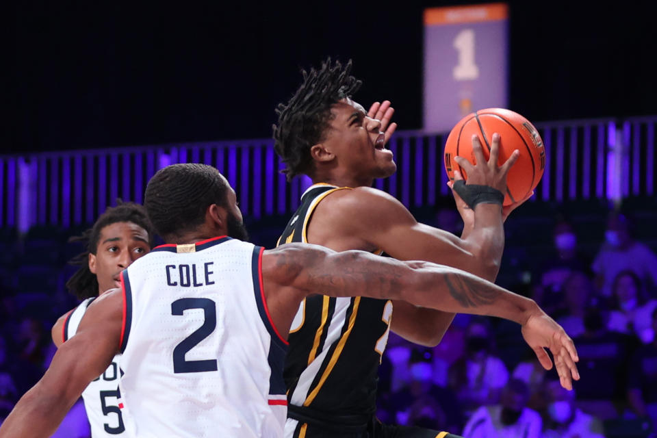 In this photo provided by Bahamas Visual Services, VCU guard Jayden Nunn (23) drives to the basket past Connecticut guard R.J. Cole (2) during an NCAA college basketball game at Paradise Island, Bahamas, Friday, Nov. 26, 2021. (Tim Aylen/Bahamas Visual Services via AP)