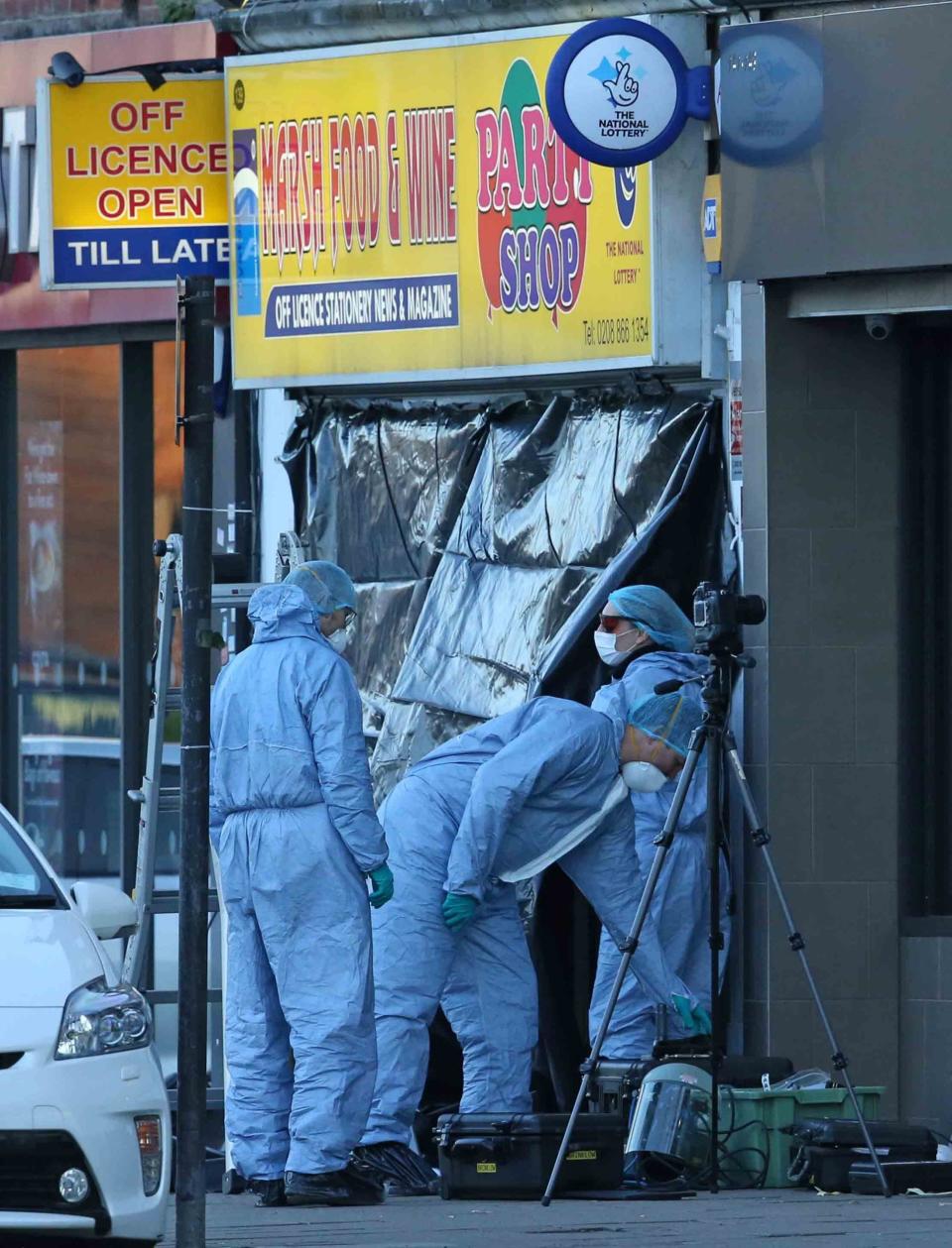 Forensics investigators outside a newsagent in Pinner (NIGEL HOWARD ©)