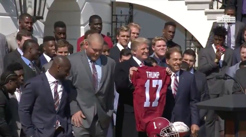 President Donald Trump holds up his special Alabama jersey. (via WhiteHouse.gov)