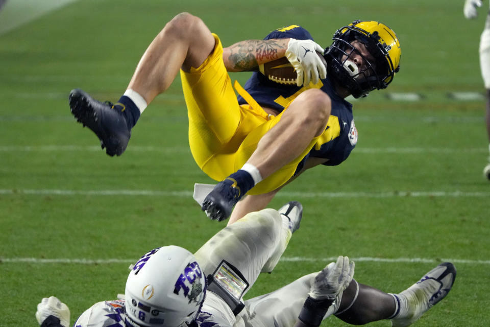 Michigan wide receiver Roman Wilson scores a touchdown as *TCU linebacker Jamoi Hodge defends during the second half of the Fiesta Bowl NCAA college football semifinal playoff game, Saturday, Dec. 31, 2022, in Glendale, Ariz. (AP Photo/Rick Scuteri)