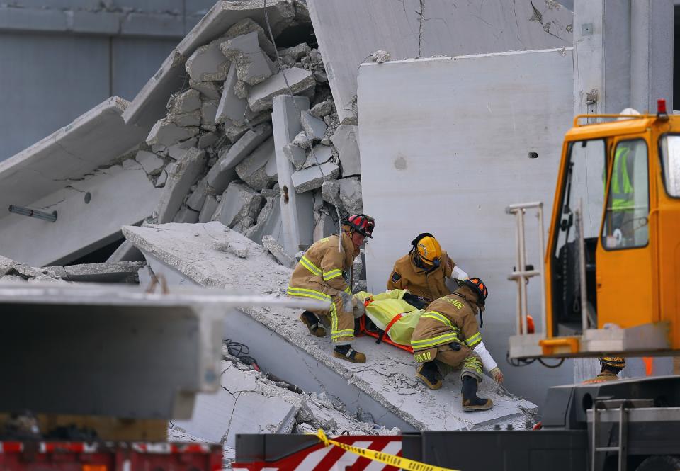 DORAL, FL - OCTOBER 10: Miami-Dade Rescue workers pull a body out of the rubble of a four-story parking garage that was under construction and collapsed at the Miami Dade College’s West Campus on October 10, 2012 in Doral, Florida. Early reports indicate that one person was killed, at least seven people injured and an unknown number of people may be buried in the rubble. (Photo by Joe Raedle/Getty Images)