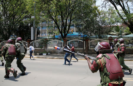 A riot policeman fires tear gas to disperse supporters of Kenyan opposition National Super Alliance (NASA) coalition, during a protest along a street in Nairobi, Kenya October 16, 2017. REUTERS/Thomas Mukoya