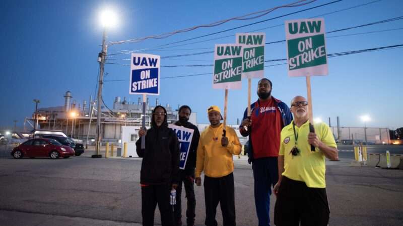 striking autoworkers holding signs