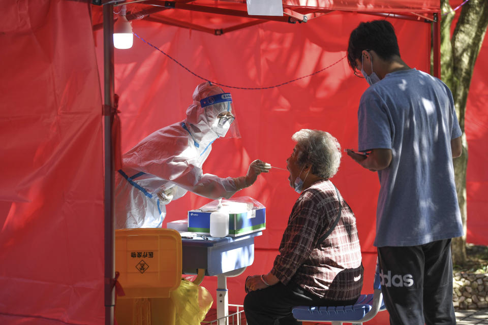 In this photo released by Xinhua News Agency, a medical worker takes a swab sample from a resident for nucleic acid test at a community testing site for COVID-19 in Yunyan District of Guiyang, southwest China's Guizhou Province, Sept. 5, 2022. In the city of Guiyang, in mountainous southern Guizhou province, a zoo put out a call for help last week, asking for pork, chicken, apples, watermelons, carrots and other produce out of concern they could run out of food for their animals. (Yang Wenbin/Xinhua via AP)