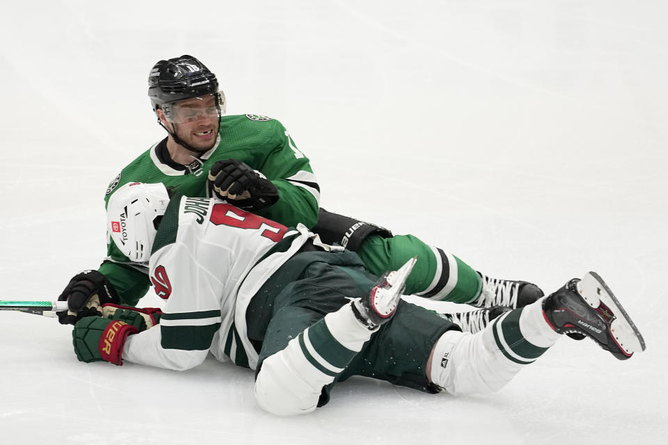 Minnesota Wild left wing Marcus Johansson, bottom, and Dallas Stars' Max Domi (18) fall to the ice after colliding as they chased the puck during the third period of Game 5 of an NHL hockey Stanley Cup first-round playoff series Tuesday, April 25, 2023, in Dallas. (AP Photo/Tony Gutierrez)