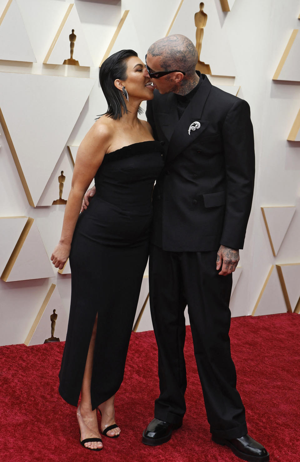 Kourtney Kardashian and Travis Barker kiss on the red carpet during the Oscars 