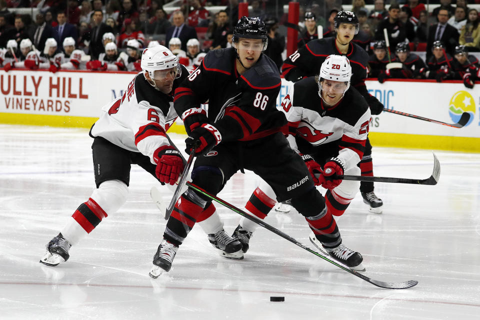 Carolina Hurricanes' Teuvo Teravainen (86), of Finland, splits the defense of New Jersey Devils' Andy Greene (6) and Blake Coleman (20) during the second period of an NHL hockey game in Raleigh, N.C., Friday, Feb. 14, 2020. (AP Photo/Karl B DeBlaker)