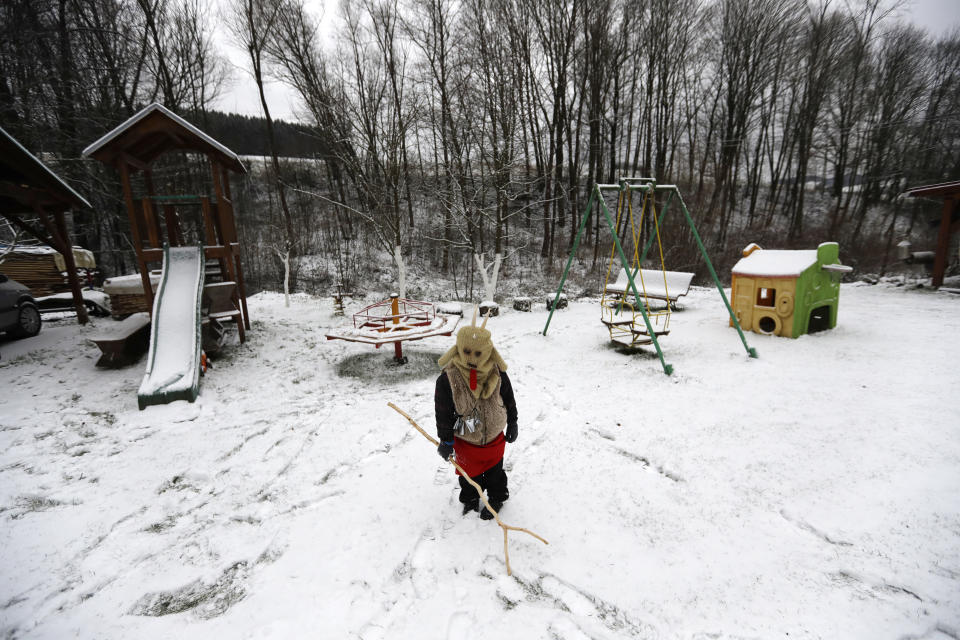 A young child dressed as a devil waits for a traditional St Nicholas procession in the village of Valasska Polanka, Czech Republic, Saturday, Dec. 7, 2019. This pre-Christmas tradition has survived for centuries in a few villages in the eastern part of the country. The whole group parades through village for the weekend, going from door to door. St.Nicholas presents the kids with sweets. The devils wearing home made masks of sheep skin and the white creatures representing death with scythes frighten them. (AP Photo/Petr David Josek)