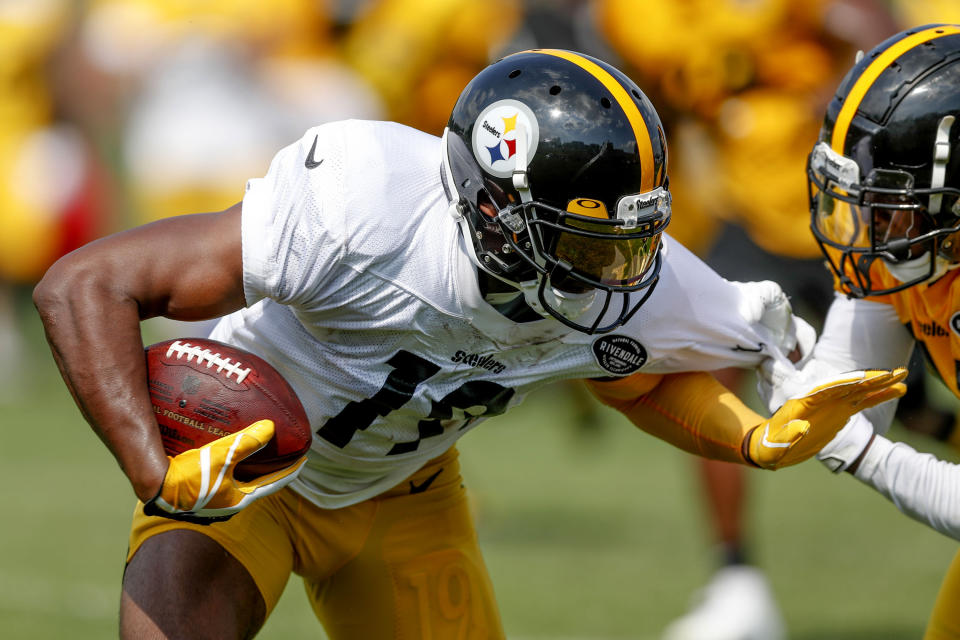 Pittsburgh Steelers wide receiver JuJu Smith-Schuster (19) is grabbed by cornerback Artie Burns, right, after making a catch during an NFL football training camp practice in Latrobe, Pa., Sunday, July 28, 2019. (AP Photo/Keith Srakocic)