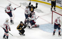 Boston Bruins defenseman Charlie McAvoy (73) celebrates after scoring the winning goal as Washington Capitals goaltender Vitek Vanecek (41) and Trevor van Riemsdyk (57) react late in the third period of an NHL hockey game, Thursday, Jan. 20, 2022, in Boston. (AP Photo/Mary Schwalm)