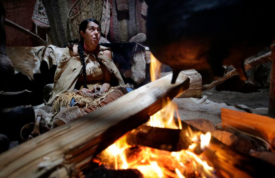 Mashpee Wampanoag Kerri Helme, of Fairhaven, uses plant fiber to weave a basket while sitting next to a fire on November 15, 2018, at the Wampanoag Homesite at the Plimoth Patuxet Museums, in Plymouth.