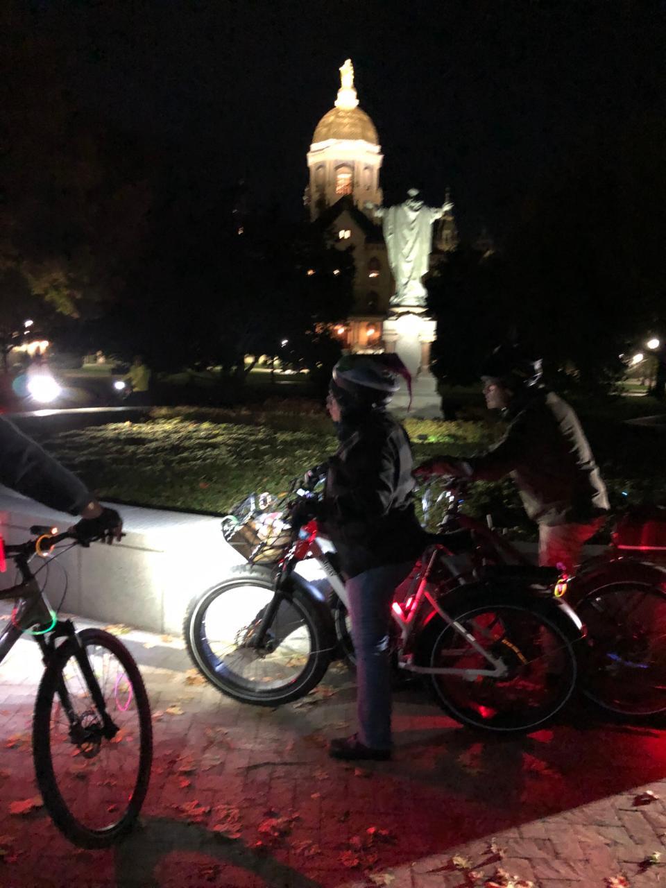 Cyclists pause at the University of Notre Dame on a night bike ride in fall 2022. Another night ride is coming up for 2023's Michiana Bike to Work Week.