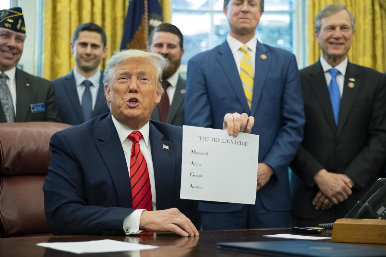 President Donald Trump shows a paper with names of four US companies worth over a trillion dollar to emphasise how good the economy is doing: (AP Photo/Manuel Balce Ceneta)