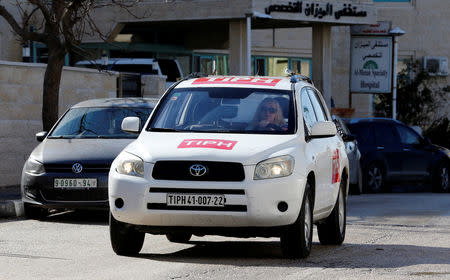 A member of the Temporary International Presence in Hebron (TIPH) drives her vehicle in Hebron, in the Israeli-occupied West Bank January 29, 2019. REUTERS/Mussa Qawasma