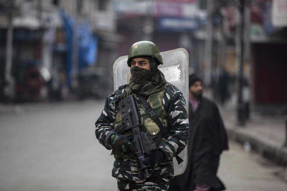 An Indian paramilitary soldier patrols through a closed market in Srinagar, Indian controlled Kashmir, Tuesday, Feb. 9, 2021. Businesses and shops have closed in many parts of Indian-controlled Kashmir to mark the eighth anniversary of the secret execution of a Kashmiri man in New Delhi. Hundreds of armed police and paramilitary soldiers in riot gear patrolled as most residents stayed indoors in the disputed region's main city of Srinagar. (AP Photo/Mukhtar Khan)