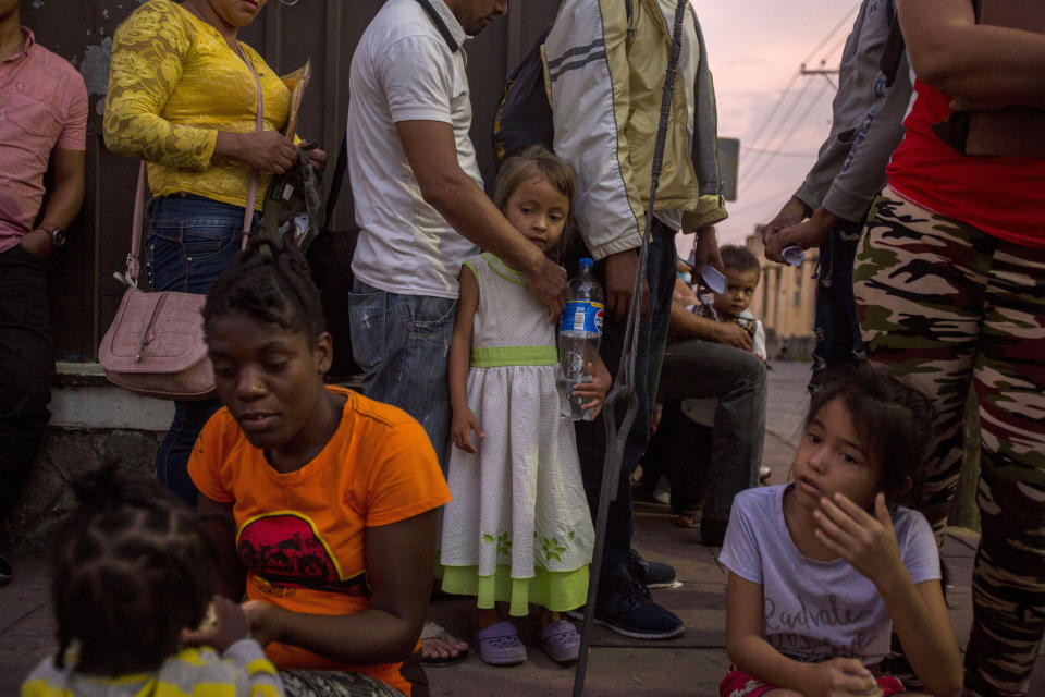 Migrants wait in line outside the Mexican Commission for Migrant Assistance office to get the documents needed that allows them to stay in Mexico, in Tapachula, Thursday, June 20, 2019. The flow of migrants into southern Mexico has seemed to slow in recent days as more soldiers, marines, federal police, many as part of Mexico's newly formed National Guard, deploy to the border under a tougher new policy adopted at a time of increased pressure from the Trump administration. (AP Photo/Oliver de Ros)