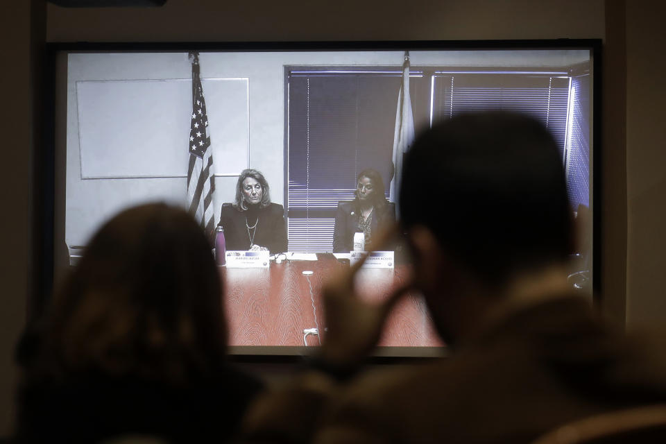 California Public Utilities Commission President Marybel Batjer, from left on video screen, and Commissioner Martha Guzman speak during a CPUC meeting in San Francisco, Wednesday, Nov. 13, 2019. California regulators will vote Wednesday on whether to open an investigation into pre-emptive power outages that blacked out large parts of the state for much of October as strong winds sparked fears of wildfires. (AP Photo/Jeff Chiu)