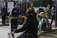 People wait outside the first aid area of the Cardarelli hospital in Naples, Italy, Friday, Nov. 13, 2020. Italian Government and health officials were analyzing data to see if the hard-strapped Campania region, which includes Naples, should be declared a red-zone. (AP Photo/Gregorio Borgia)