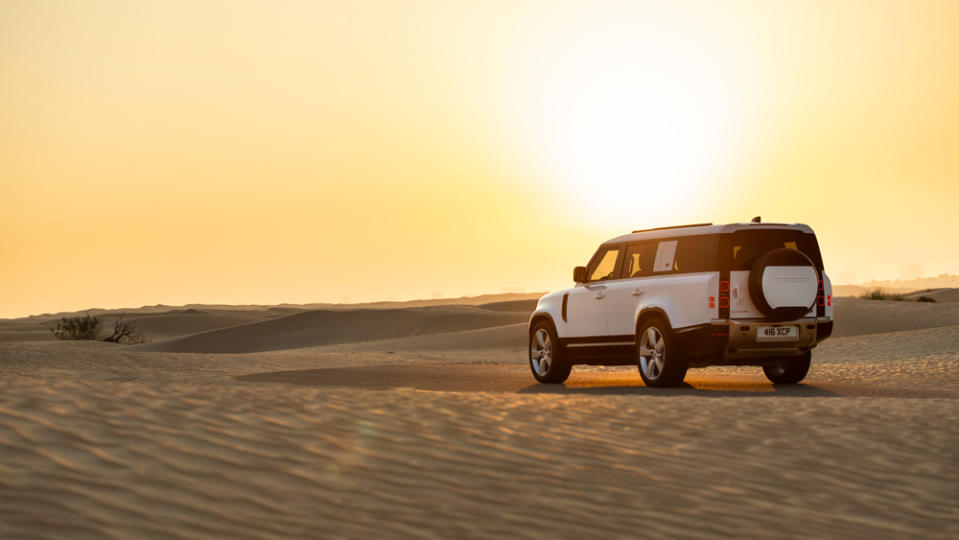 A 2023 Land Rover Defender 130 amidst the sand dunes of Dubai.