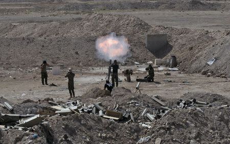 Members of the Iraqi army and Shi'ite fighters launch a mortar toward Islamic State militants outskirt the city of Falluja, Iraq May 19, 2015. REUTERS/Stringer