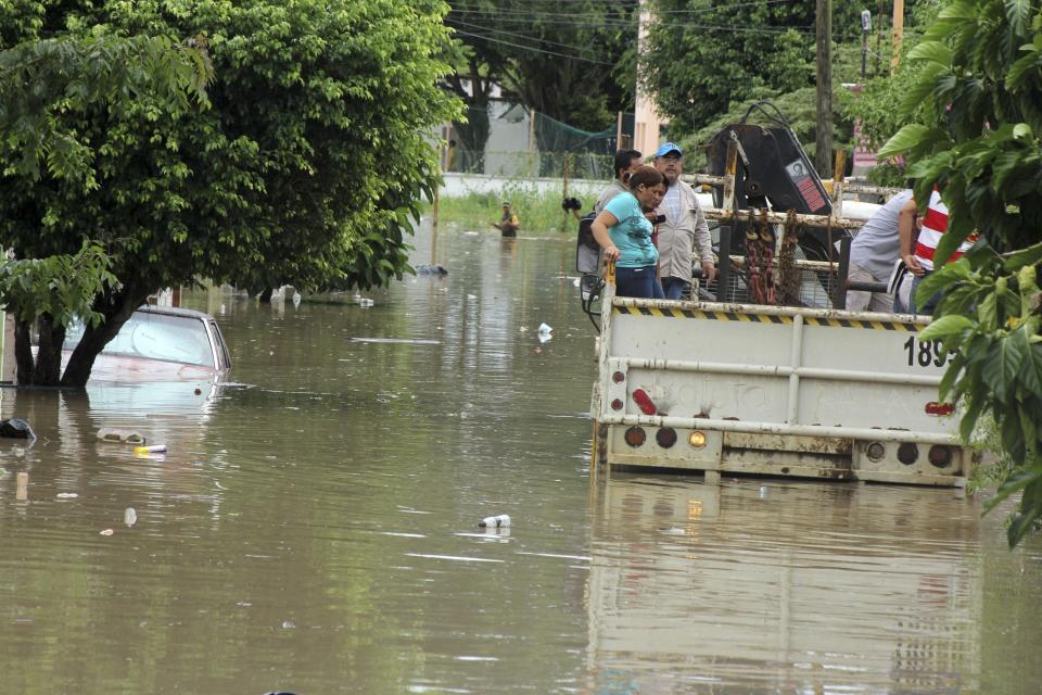 Flood-affected residents travel on the back of a truck through a flooded neighbourhood in Poza Rica, in the Mexican state of Veracruz September 14, 2013. Hurricane Ingrid strengthened on Saturday night as it spun off Mexico's Gulf Coast, dumping heavy rain across central and eastern Mexico. Ingrid, with sustained winds of 80 miles per hour (130 kph), could grow even stronger over the next two days as it nears Mexico's coast, the U.S. National Hurricane Center said. REUTERS/Jorge Huerta