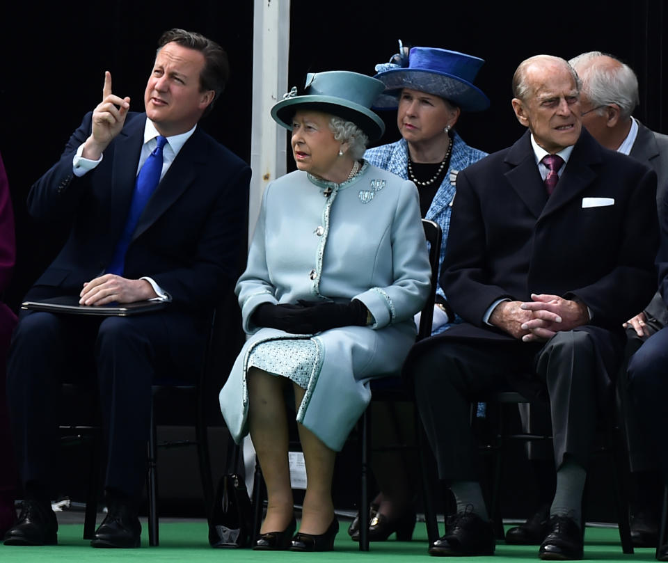 RUNNYMEDE, ENGLAND - JUNE 15:  British Prime Minister David Cameron (L) gestures sat next to Britain's Queen Elizabeth II (C) and Prince Philip, Duke of Edinburgh (R) as they attend a service to mark the 800th anniversary of Magna Carta on June 15, 2015 in Runnymede, United Kingdom. Members of the Royal Family are visiting Runnymede to attend an event commemorating the 800th anniversary of Magna Carta. Magna Carta is widely recognised as one of the most significant documents in history. Its influence, as a cornerstone of fundamental liberties, is felt around the world in the constitutions and political traditions of countless nations. (Photo by Ben Stansall - WPA Pool / Getty Images)