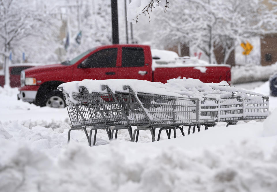 Shopping carts topped with heavy snow sit marooned in the lot of a grocery store as a late winter storm dropped up to a foot of snow Thursday, March 14, 2024, in Golden, Colo. Forecasters predict that the storm will persist until early Friday, snarling traffic along Colorado's Front Range communities. (AP Photo/David Zalubowski)