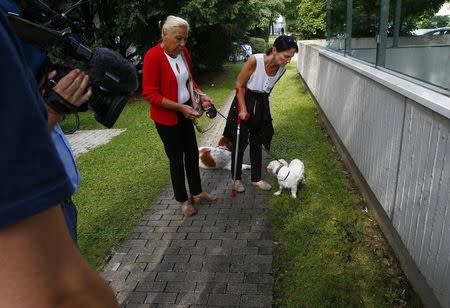 Women and TV look at the place where German-Iranian teenager died, who shot dead nine people in Munich, Germany July 24, 2016. REUTERS/Arnd Wiegmann