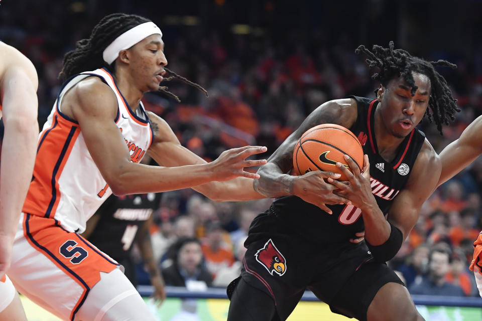 Louisville guard/forward Mike James, right, fights for a rebound against Syracuse forward Maliq Brown during the first half of an NCAA college basketball game in Syracuse, N.Y., Wednesday, Feb. 7, 2024. (AP Photo/Adrian Kraus)