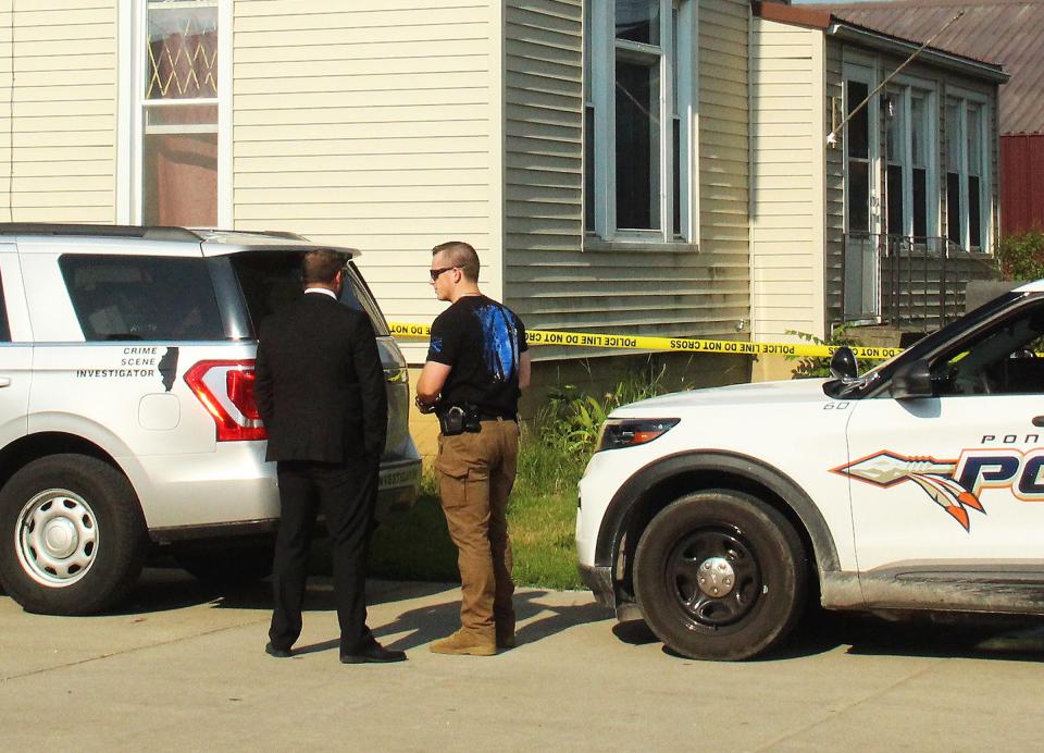 Livingston County State's Attorney Mike Regnier, left, discusses the situation in the 500 block of West Howard Street residence with an investigator Wednesday morning. A 49-year-old female was apparently shot earlier in the morning at the 512 W. Howard St. residence.