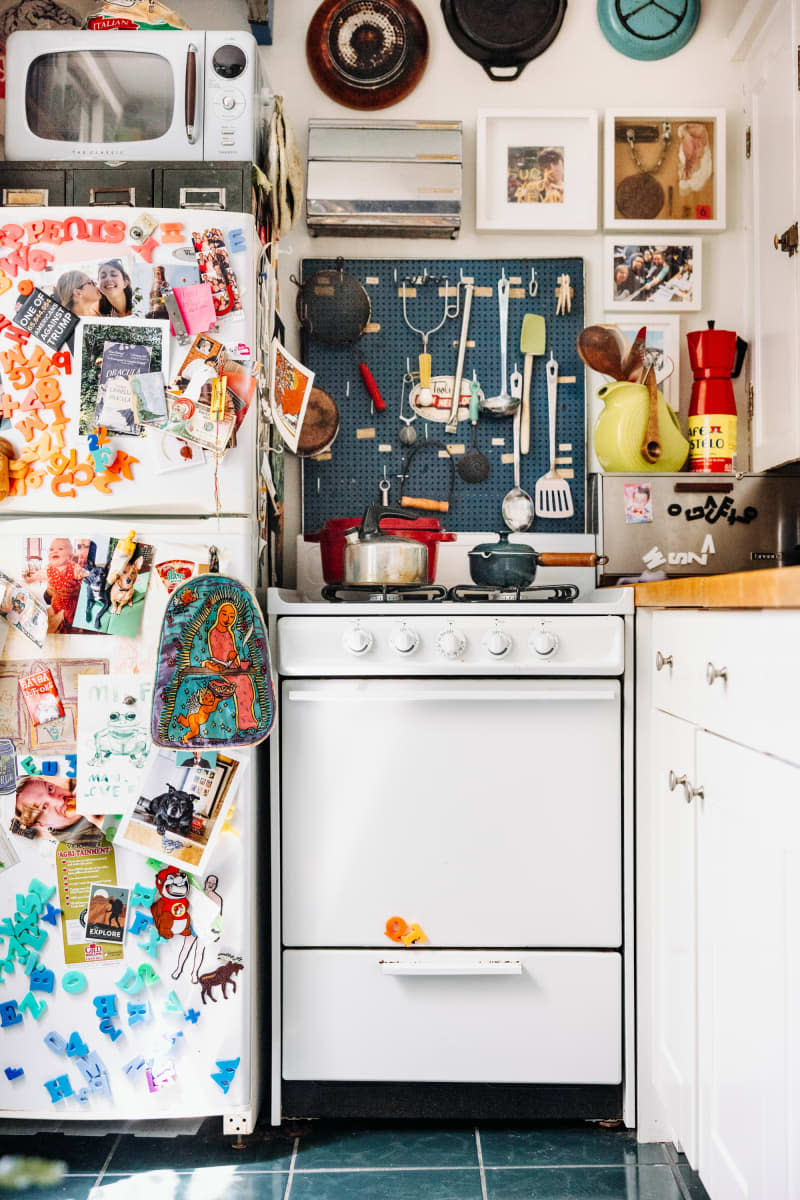 Maximalist kitchen with dozens of magnets on a fridge.